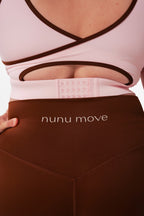 Close-up of the Nunu Move Cherry Blossom Asta nursing bra's wide multi-row hook-and-eye back clasp, above the Espresso brown V-Bum shorts waistband.