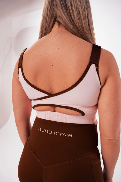 Back view of the Nunu Move Cherry Blossom nursing bra showing the crossover straps and multi-row adjustable back clasp, worn with Espresso brown V-Bum shorts.